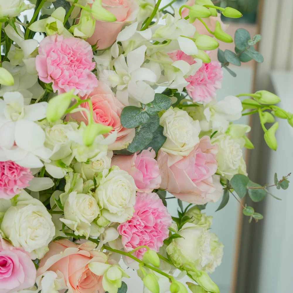 A box arrangement of 20 white orchids, 12 pink roses, 12 pink carnations and 5 white spray roses with green fillers.