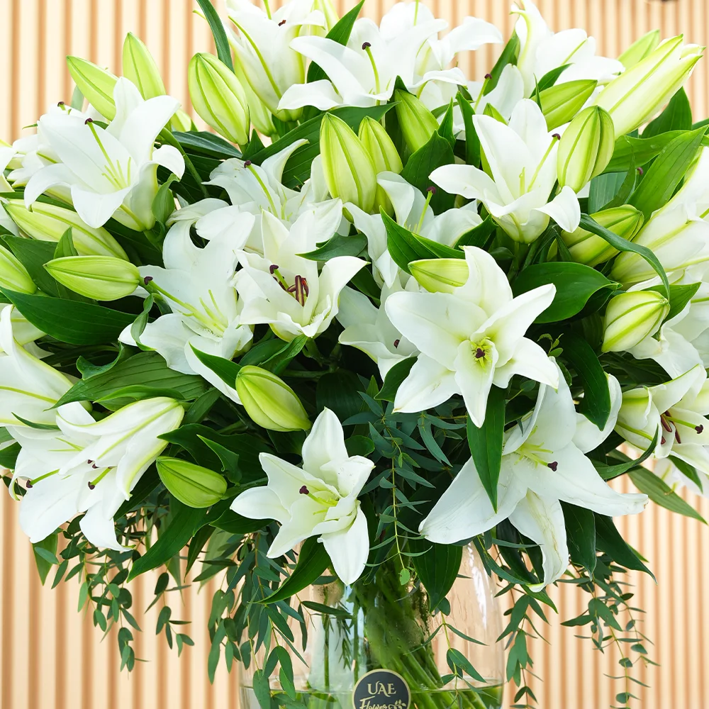 glass vase with 20 white lilies and green fillers