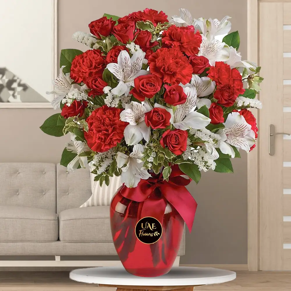 10 red carnations, 5 white alstroemeria, 5 red spray roses, and green fillers in a glass vase