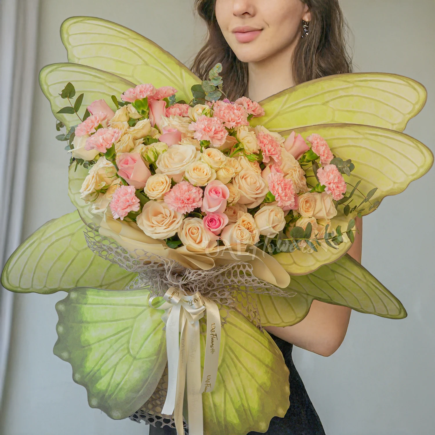 bouquet of 5 peach roses, 5 peach spray roses, 15 pink carnations, and 7 pink roses.