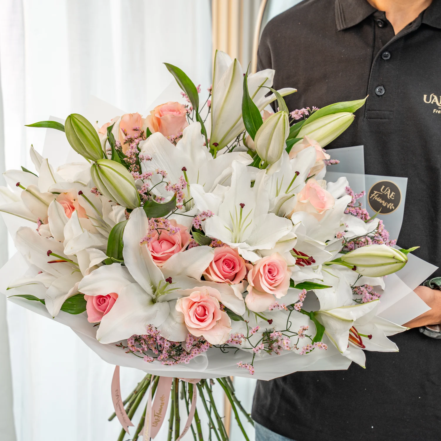 12 pink roses, 5 white lilies, statice, and greenery