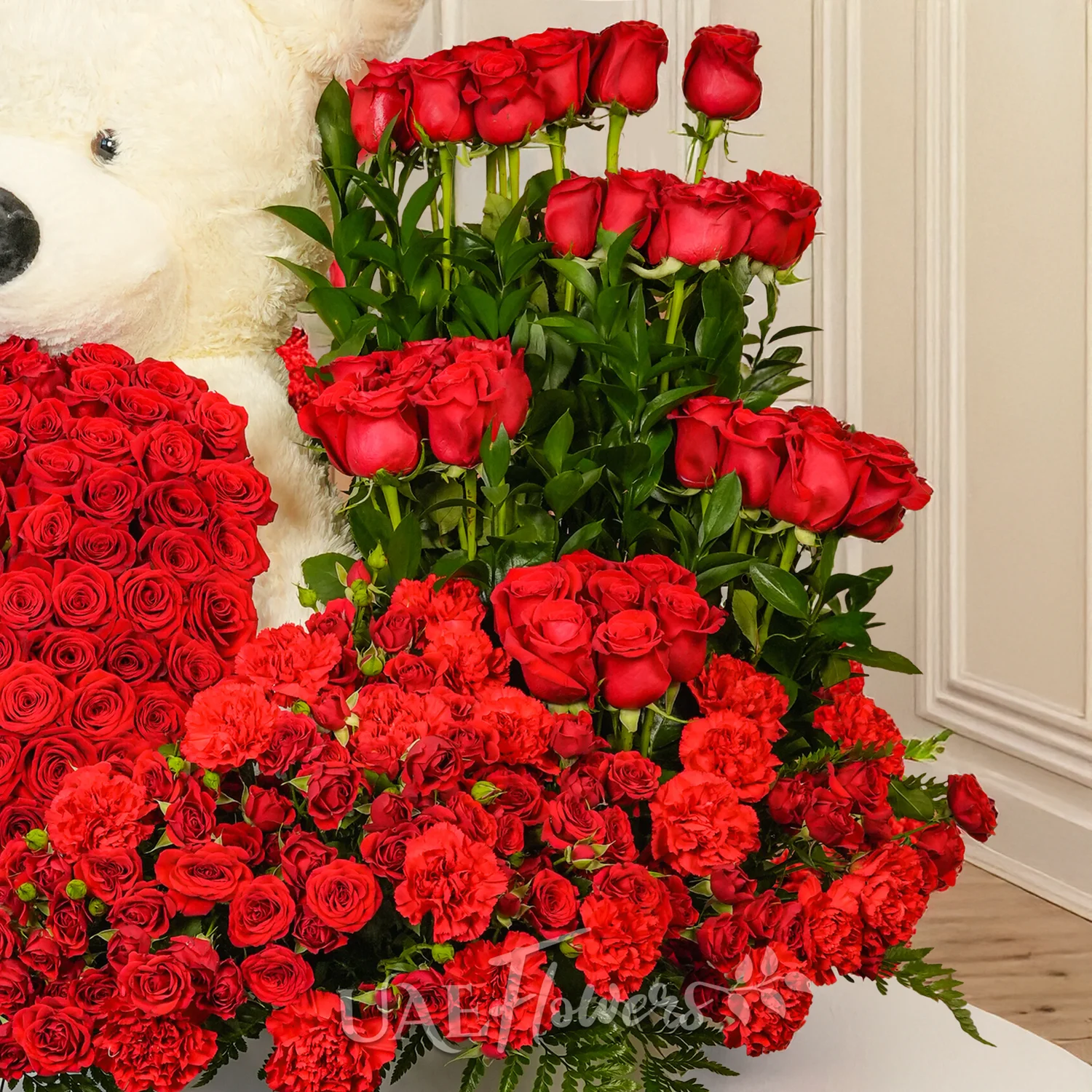 floral heart and box arrangements of 150 red roses with fillers and 1 large white teddy bear.