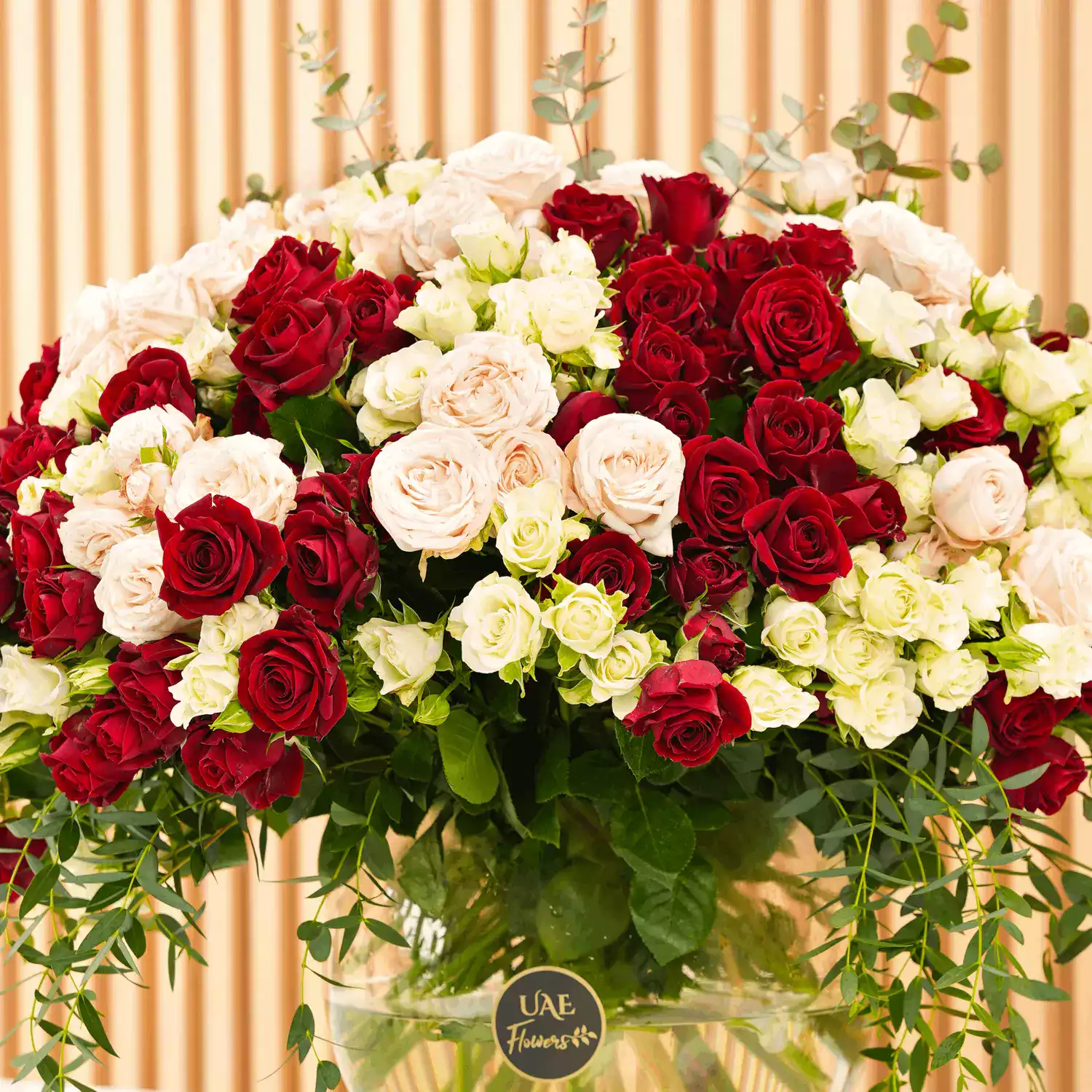 glass vase with red, pink, and white spray roses with green fillers