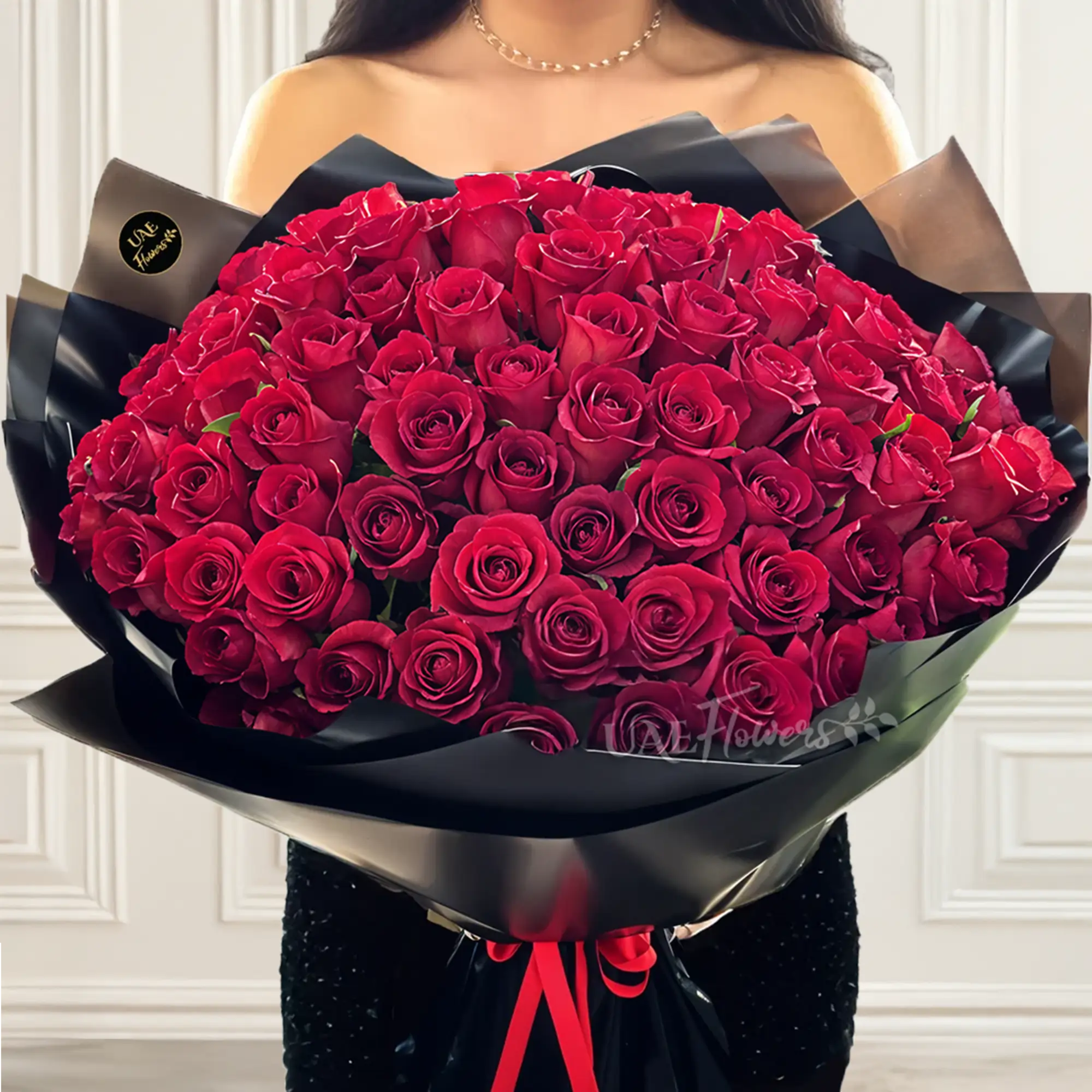 A romantic bouquet of 100 red roses in black wrapping paper tied with black ribbon A romantic bouquet of 100 red roses in black wrapping paper tied with black ribbon