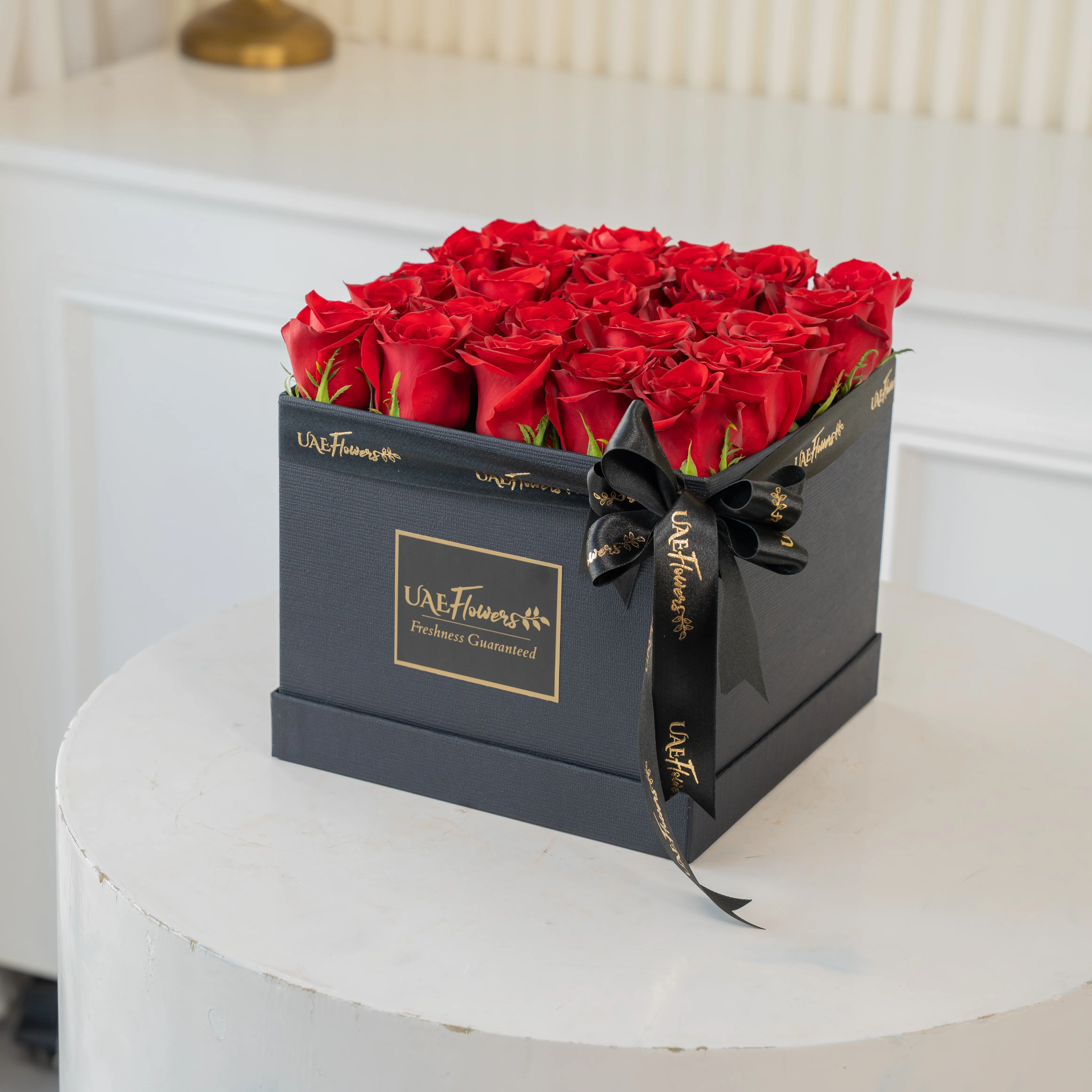 25 red roses in a square box.