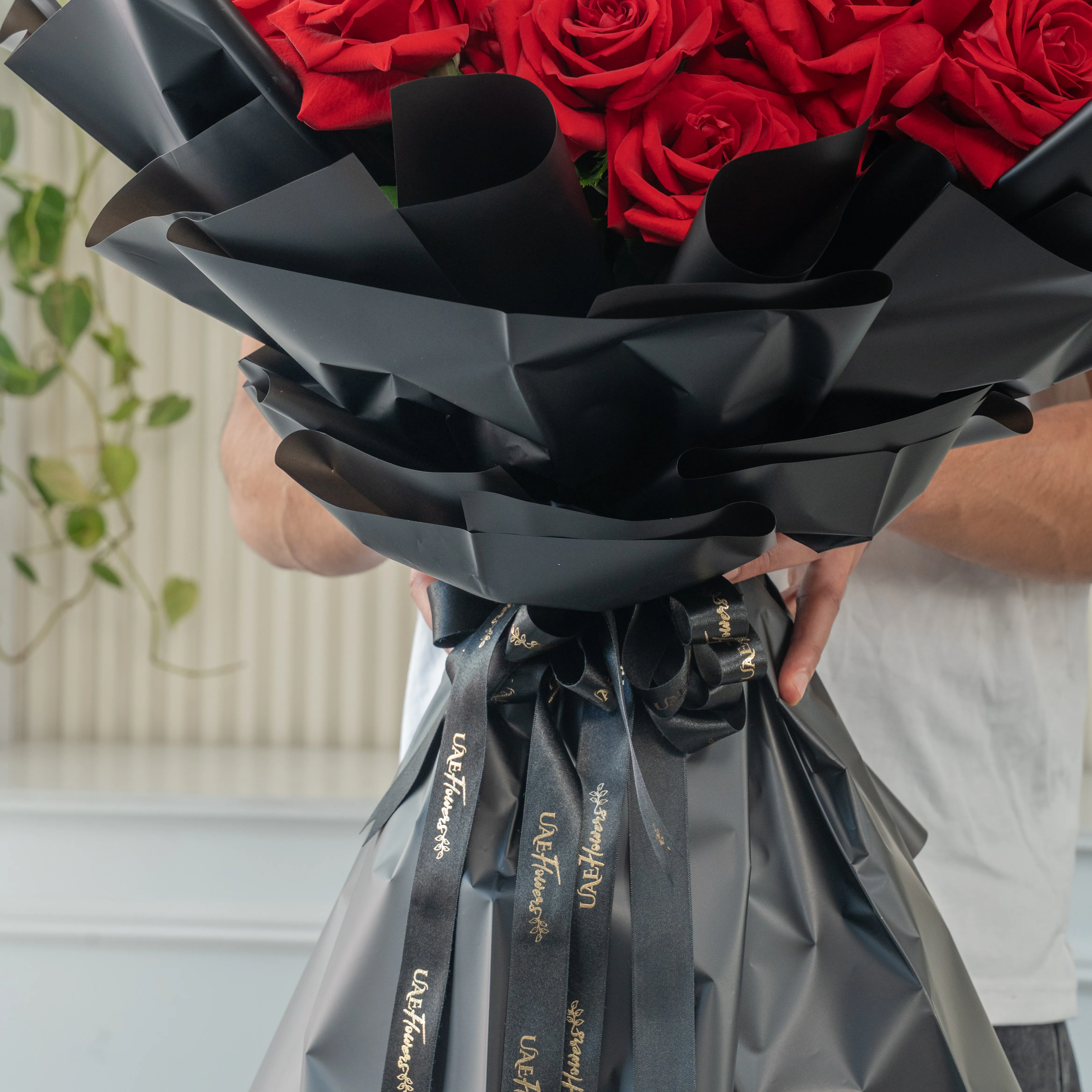 Bouquet of 25 red roses in black paper packing