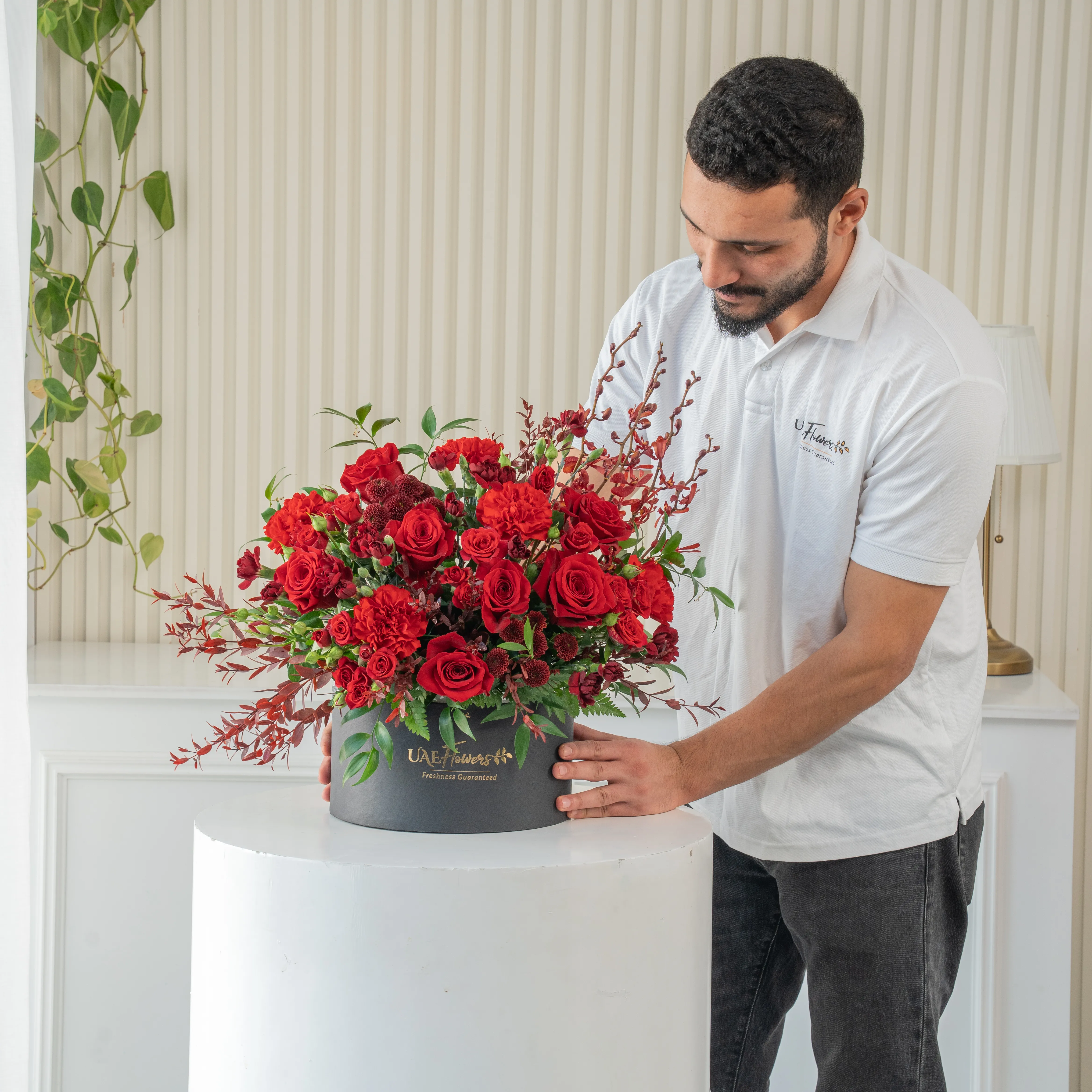 4 annie black orchids, 8 red roses, 3 red spray roses, 2 red chrysanthemums and 4 red spray carnations with green fillers in a round box.