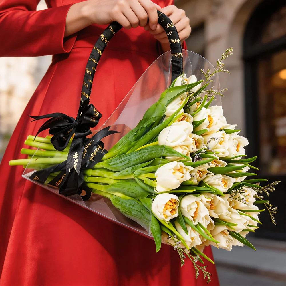 20 white tulips arranged in a chic acrylic bag tied with a black ribbon