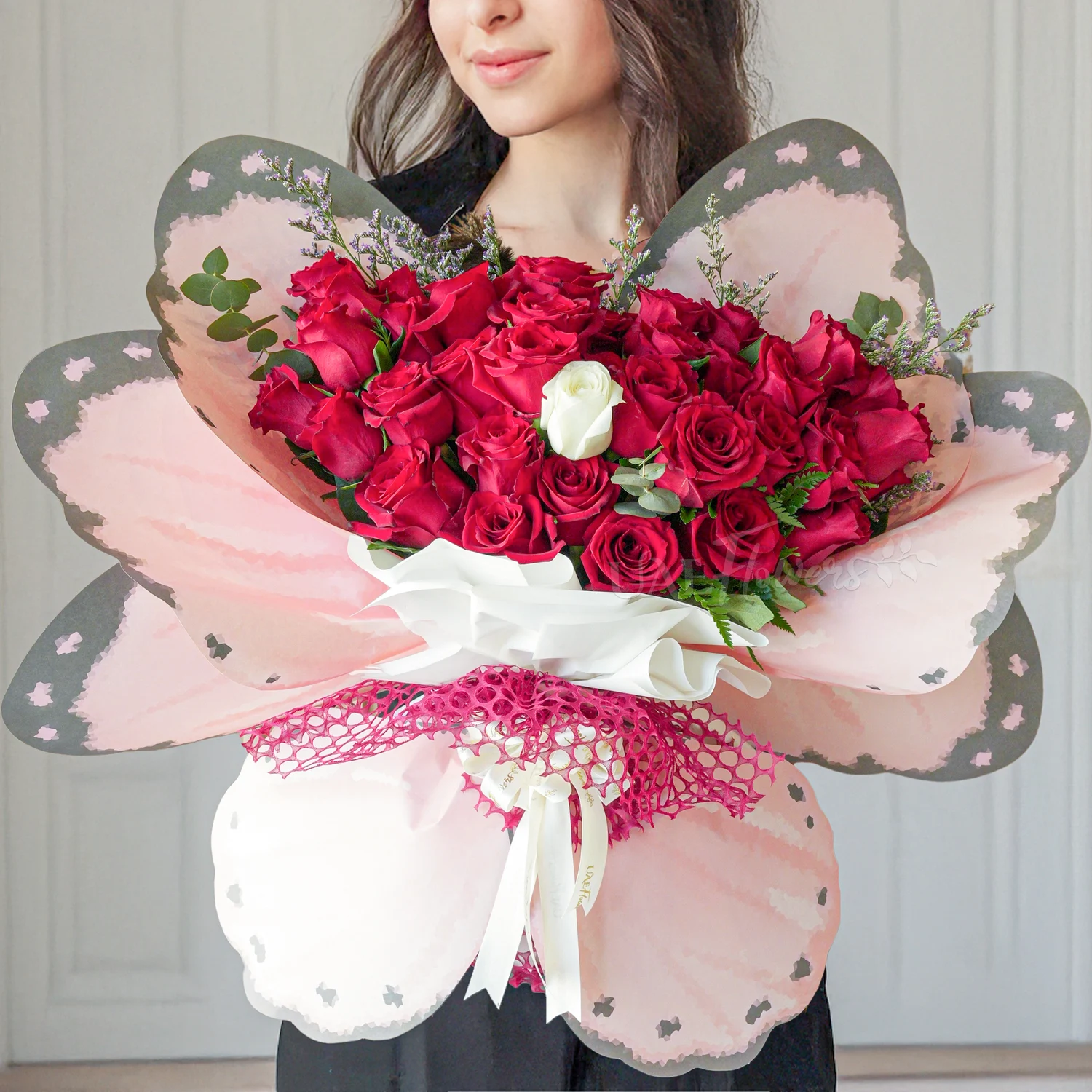 butterfly bouquet of 35 red roses and 1 white rose with fillers tied with ribbons